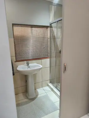 a bathroom with a sink and a shower at Peaceful Private Secure Bachelor Flat in Pretoria