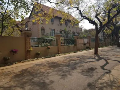 a house on a street with a fence at Court Classique Suite Hotel in Pretoria