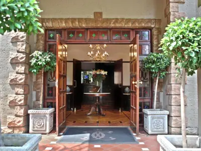 an entrance to a building with a table and a chandelier at Court Classique Suite Hotel in Pretoria