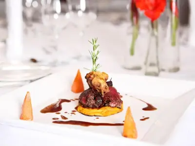 a white plate with food on a table at Court Classique Suite Hotel in Pretoria
