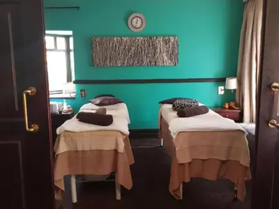 two beds in a room with a green wall at Court Classique Suite Hotel in Pretoria