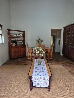 a living room with a table with flowers on it at The Macadamia Nut Farm House in White River