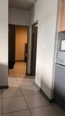 a hallway of an empty room with white walls and tile floors at The Legacy Loft in Kyalami
