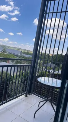 a table on a balcony with a view of the water at The Legacy Loft in Kyalami