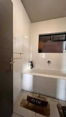 a bathroom with a bath tub and a window at The Legacy Loft in Kyalami