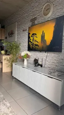 a large tv on a brick wall in a room at The Legacy Loft in Kyalami