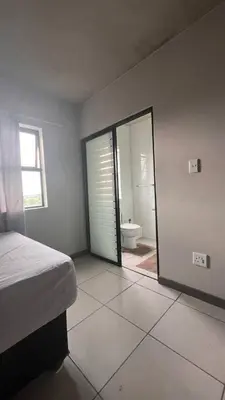 a bedroom with a bed and a bathroom with a toilet at The Legacy Loft in Kyalami