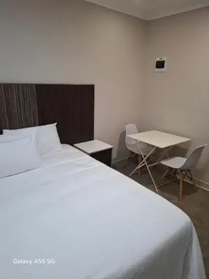 a bedroom with a large white bed and a table at Petron home in Kempton Park
