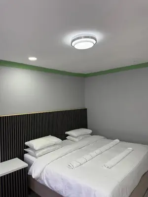 a bedroom with a large bed with white sheets and pillows at Petron home in Kempton Park