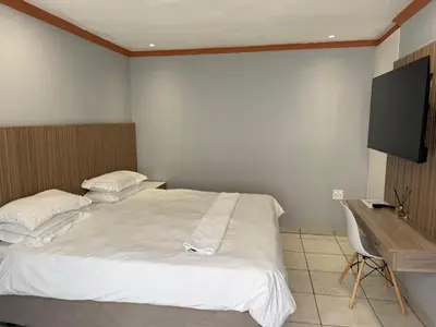 a bedroom with two white beds and a desk at Petron home in Kempton Park