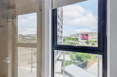 a window with a view of a building at 4316 Ellipse luxury Apartment, Waterfall in Midrand