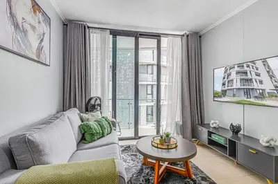 a living room with a couch and a table at 4316 Ellipse luxury Apartment, Waterfall in Midrand