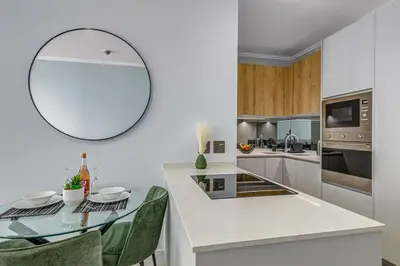 a kitchen with a table and a mirror on the wall at 4316 Ellipse luxury Apartment, Waterfall in Midrand
