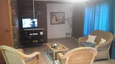 a living room with two chairs and a television at Do Drop In in Hoedspruit