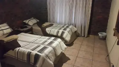a room with two beds and a window at Do Drop In in Hoedspruit