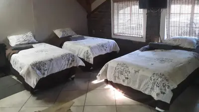 a room with two beds with white comforters at Do Drop In in Hoedspruit