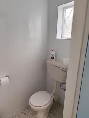 a white bathroom with a toilet and a window at 899 On Burlington in Pretoria