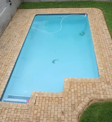 a swimming pool with blue water in the middle at 899 On Burlington in Pretoria