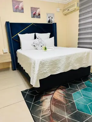 a bedroom with a large bed with a blue headboard at C-Rane Lodge B in Phalaborwa