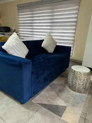 a blue couch with two pillows in a living room at C-Rane Lodge B in Phalaborwa