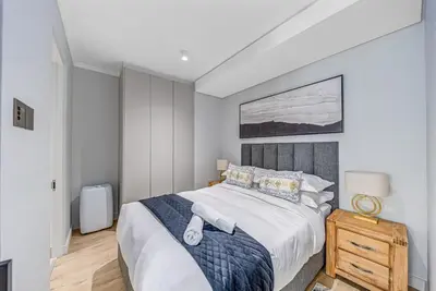 a bedroom with a large bed with white sheets and pillows at Skyline Serenity in Midrand