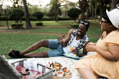 a man and a woman sitting on the grass in a park at Tzaneen Country Lodge in Tzaneen