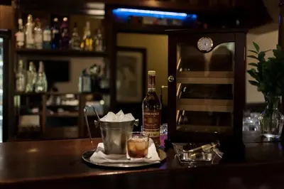 a bar with a drink and a bottle of alcohol at Tzaneen Country Lodge in Tzaneen