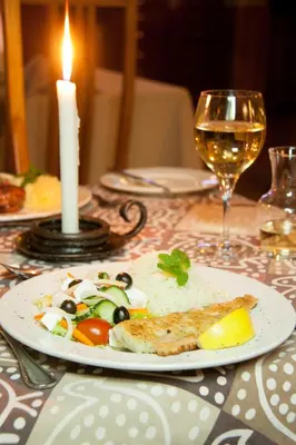 a plate of food on a table with a candle at Tzaneen Country Lodge in Tzaneen
