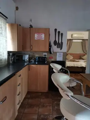 a kitchen with a white chair in a room at Impala Lily Kaya in Marloth Park