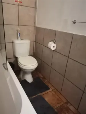 a bathroom with a toilet and a bath tub at Impala Lily Kaya in Marloth Park