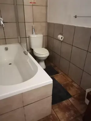 a bathroom with a white tub and a toilet at Impala Lily Kaya in Marloth Park