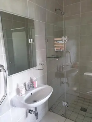 a bathroom with a sink and a glass shower at Nompu b&b in Pretoria