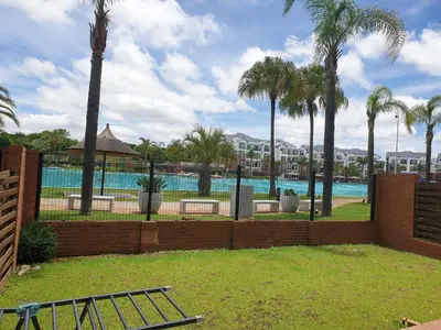 a swimming pool with palm trees and a fence at Nompu b&b in Pretoria