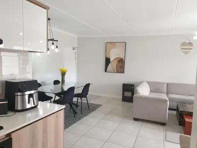 a kitchen and living room with a couch and a table at Nompu b&b in Pretoria