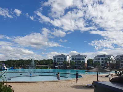 a large swimming pool with a fountain in front of condos at Nompu b&b in Pretoria