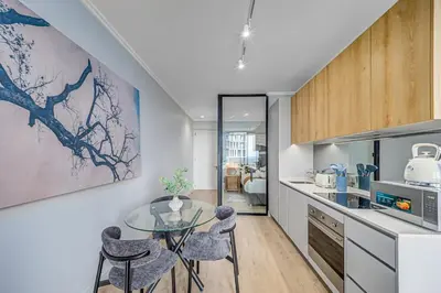 a kitchen with a glass table and some chairs at The Orbit in Midrand