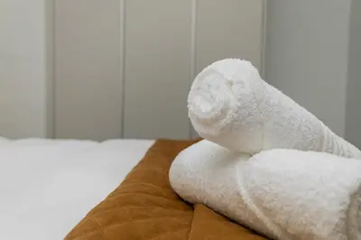 a white towel sitting on top of a bed at The Orbit in Midrand