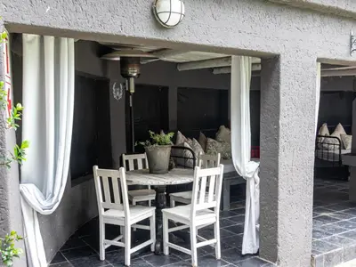 a table and chairs on the porch of a house at Muckleneuk Manor in Pretoria