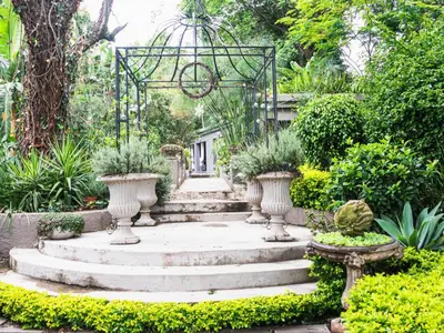 a garden with a staircase and vases with plants at Muckleneuk Manor in Pretoria