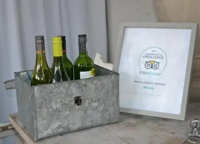 three bottles of wine in a metal container next to a box at Muckleneuk Manor in Pretoria