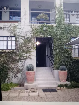 a building with stairs leading to a door with plants at Muckleneuk Manor in Pretoria