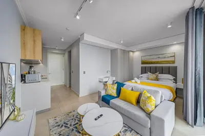 a hotel room with a bed and a couch at Golden Sun Suites in Midrand