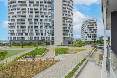 a large white building with two tall buildings at Golden Sun Suites in Midrand