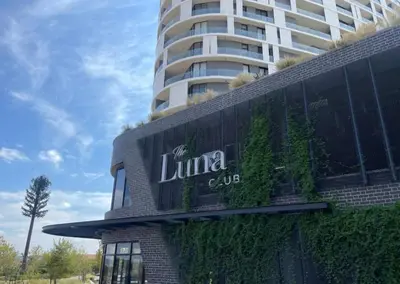 a building with a sign on it in front of a tall building at Ellipse Luxurious Tamarind Red Studio Experience in Midrand