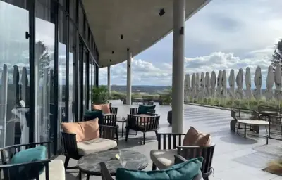 a patio with chairs and tables and windows at Ellipse Luxurious Tamarind Red Studio Experience in Midrand