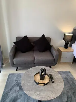 a living room with a couch and a table at Ellipse Luxurious Tamarind Red Studio Experience in Midrand