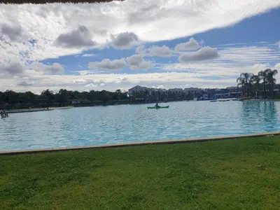 a person in a boat on a large lake at 3 Bedroom Apartment The Blyde Crystal Lagoon in Pretoria