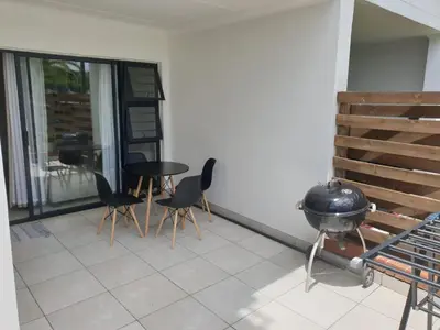 a patio with a grill and chairs and a table at 3 Bedroom Apartment The Blyde Crystal Lagoon in Pretoria