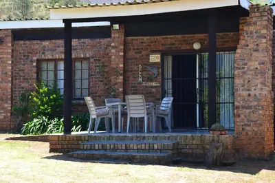 a table and chairs sitting on a porch at Trout Ways in Waterval Boven