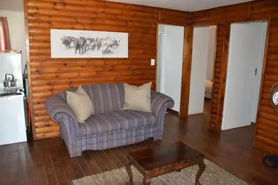 a living room with a couch and a table at Trout Ways in Waterval Boven